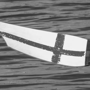 Mustavalkoinen kuva, jossa airo veden päällä. Airossaa Suomen lippu.